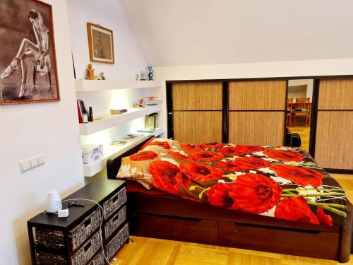 a bedroom with a bed with red flowers on it at Jeruzale Park view in Vilnius