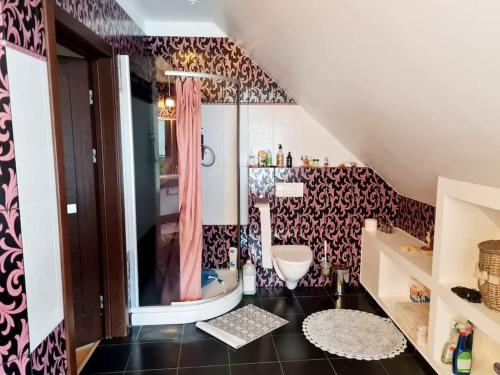a bathroom with a pink shower curtain and a toilet at Jeruzale Park view in Vilnius