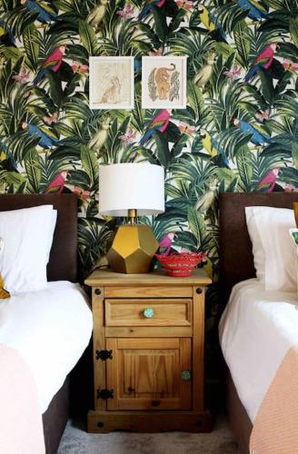 a bedroom with two beds and a lamp on a night stand at The Tree House, quiet neighbourhood in Lincolnshire