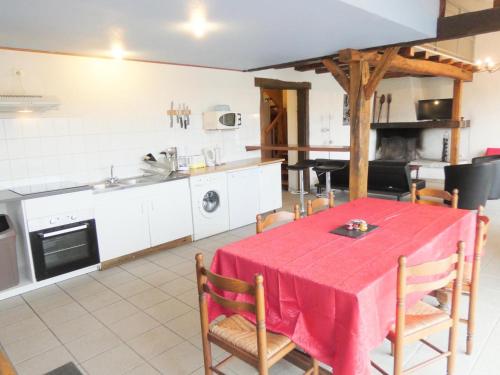 a kitchen and dining room with a red table and chairs at Les barthes in Orist