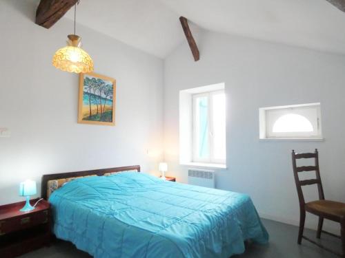 a bedroom with a blue bed and a chair at Les barthes in Orist