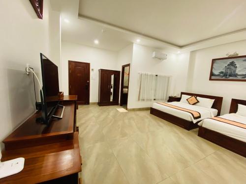 a hotel room with two beds and a television at Jen Hotel in Tuy Hoa