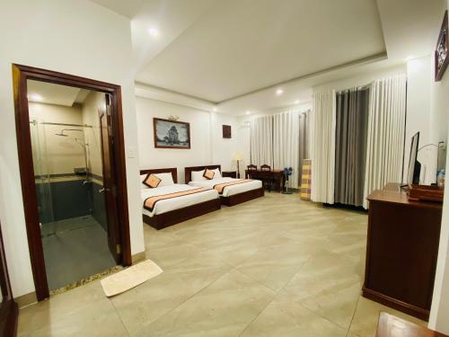 a hotel room with two beds and a shower at Jen Hotel in Tuy Hoa