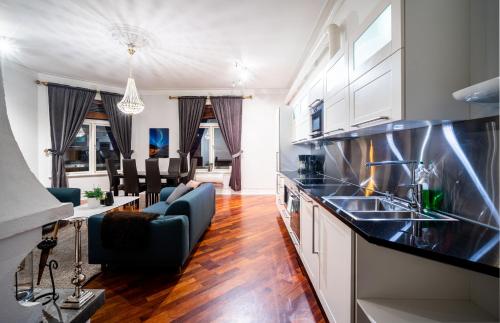 een keuken met een wastafel en een woonkamer bij Enter Tromsø Ultimate Luxury - Jacuzzi & Sauna in Tromsø