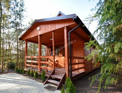 Cabaña de madera en el bosque con porche en Domki pod bocianem, en Bachórz