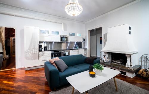 een woonkamer met een blauwe bank en een open haard bij Enter Tromsø Ultimate Luxury - Jacuzzi & Sauna in Tromsø