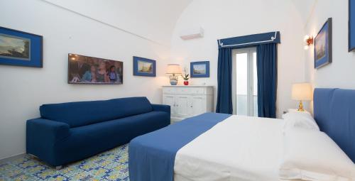 1 dormitorio con 1 cama y 1 sofá azul en Marlin Guest House, en Capri