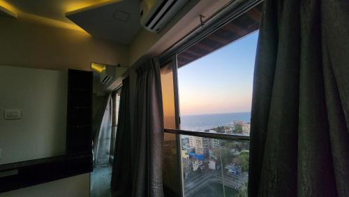 Cette chambre dispose d'une fenêtre offrant une vue sur l'océan. dans l'établissement Ocean view, à Mumbai