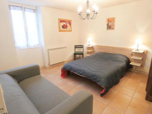 a bedroom with a bed and a couch in it at Le tuc in Orist