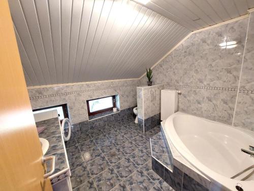 ein großes Bad mit einer Badewanne und einem Waschbecken in der Unterkunft Countryside Apartment Agnes in Šentjošt nad Horjulom