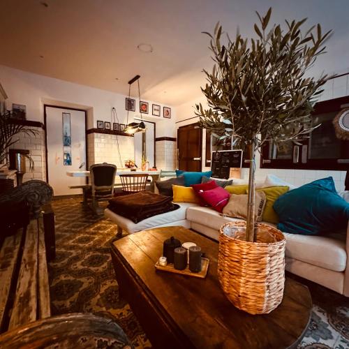 een woonkamer met een bank en een tafel met een boom bij AMPLE Conciergerie in Cierp