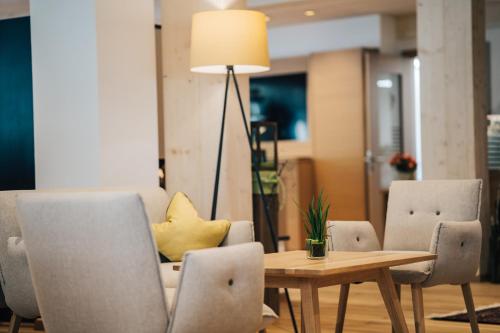 a dining room with a table and chairs and a lamp at Hotel SeeRose in Bodensdorf