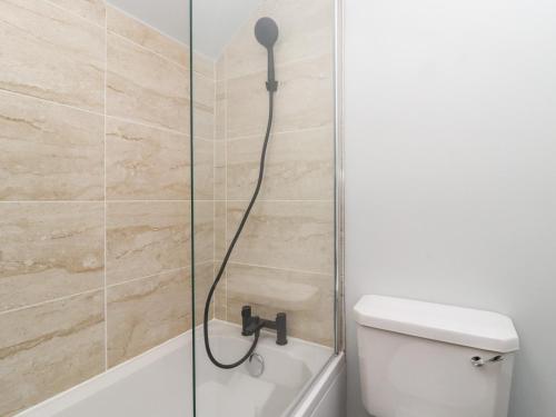 a shower with a shower head next to a toilet at The Stables in Colne