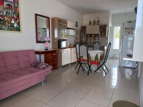 sala de estar con mesa y sofá púrpura en Lar do Sossego en Araquari