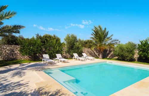 une piscine avec des chaises et une villa dans l'établissement Masseria Specchia, à Lecce