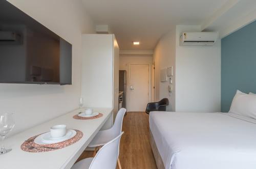 a room with a bed and a table and chairs at Setin Downtown Praca da Sé by Viva - Prédio completo com piscina perto de estação de metrô no Centro de São Paulo in Sao Paulo