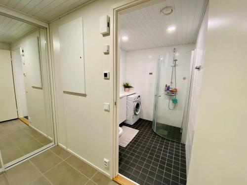 a white bathroom with a shower and a toilet at Lakeside Modern Minimalist Apartment FreeParking in Järvenpää