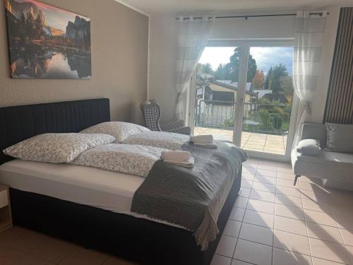 um quarto com uma cama grande e uma janela grande em Rheinview Sunset in Urbar em Urbar