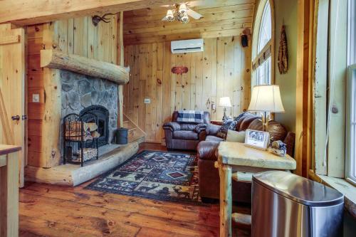 a living room with a couch and a fireplace at Rustic Retreat Walk to Great Sacandaga Lake! in Broadalbin
