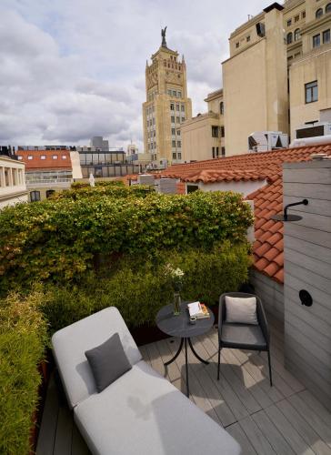 a balcony with a chair and a table on a roof at Hotel Regina in Madrid