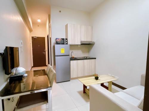 a small kitchen with a refrigerator and a table at Admiral Baysuites 1 BR Unit in Manila