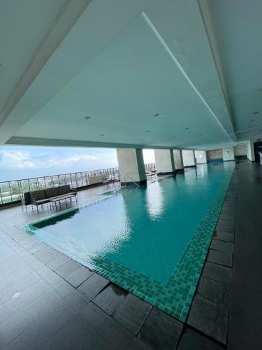a large swimming pool in a building at Admiral Baysuites 1 BR Unit in Manila