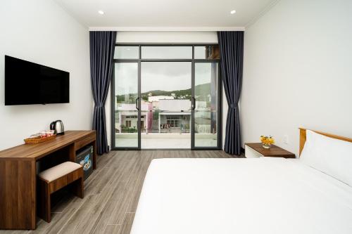 une chambre d'hôtel avec un lit et une télévision dans l'établissement UYÊN GIA HOTEL-PHÚ QUỐC, à Duong Dong