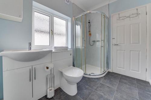 a bathroom with a toilet and a sink and a shower at Pass the Keys Cosy Bungalow in Sheffield in Sheffield