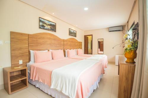 a hotel room with two beds with pink sheets at Terra dos Diamantes Hotel in Lençóis