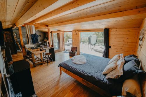 a bedroom with a bed in a wooden house at Le Fruit du Chêne in Hamoir