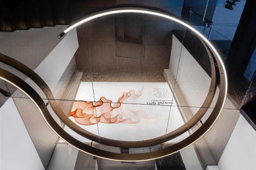 a spiral staircase in a museum with a painting on it at The Street Milano Duomo | a Design Boutique Hotel in Milan