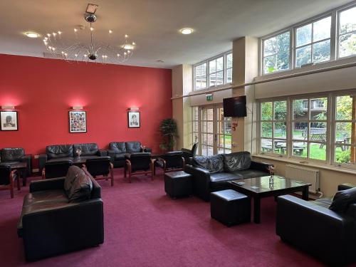 uma sala de espera com sofás e cadeiras e uma televisão em Luther King House em Manchester