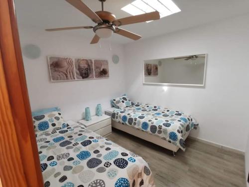 sypialnia z 2 łóżkami i wentylatorem sufitowym w obiekcie Bungalow Primavera w Puerto del Carmen