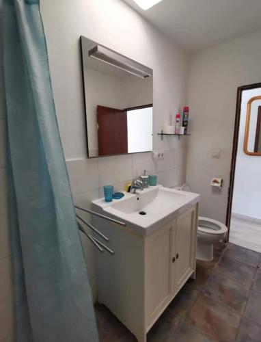 a bathroom with a sink and a toilet and a mirror at Bungalow Primavera in Puerto del Carmen