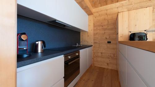 uma cozinha com armários brancos e um balcão preto em Sertorelli 27 em Bormio