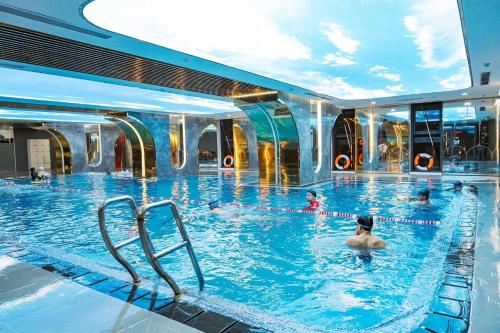 a swimming pool in a building with people in it at Homestay Honey Appartment Hải Phòng 2 - Hoàng Huy Grand Tower in Hai Phong