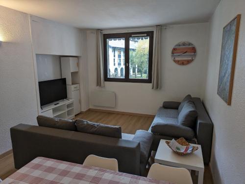 un salon avec un canapé et une télévision dans l'établissement Central spacious flat with private parking, à Chamonix-Mont-Blanc