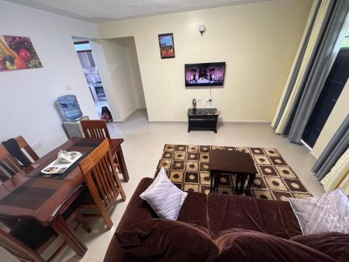 a living room with a couch and a table at Kef Apartments in Nanyuki