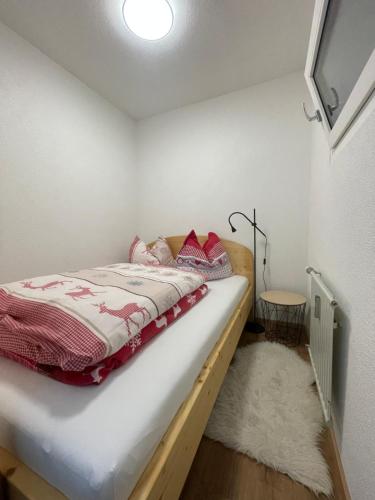 a small bedroom with a bed and a rug at vom See auf die Skipiste in Feldkirchen in Kärnten