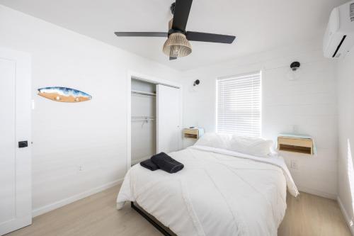 a white bedroom with a bed and a ceiling fan at Beach Block-1min Walk-Luxury-The Reef Upstairs in Ocean City