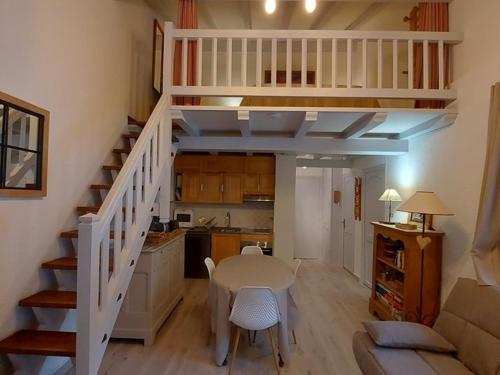 un salon avec un escalier avec une table et une cuisine dans l'établissement Appartement rénové 4 pers., pied des pistes, parking - FR-1-733-31, à Crest-Voland