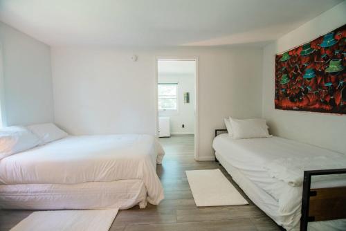 um quarto com duas camas e um quadro na parede em The Flat a Wanderlust Abodes property em Central Lake