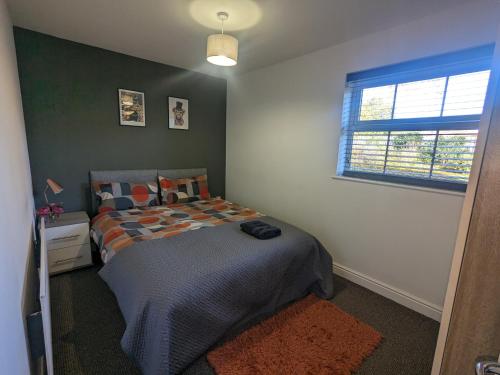 a bedroom with a bed and a window at Superb Modern Apartment, FREE Secure Parking! in Allesley