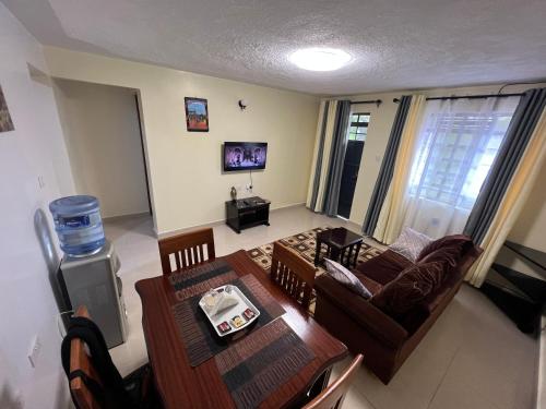 Kef Apartments في نانيوكي: غرفة معيشة مع أريكة وطاولة