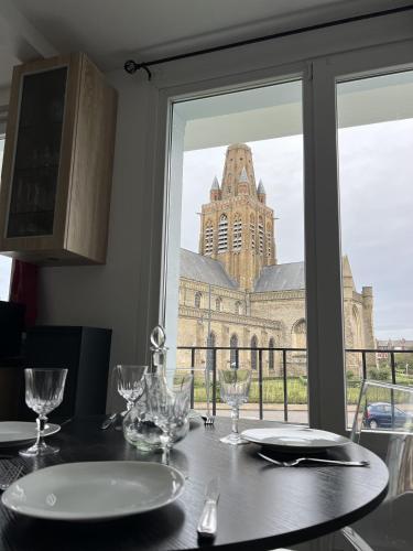 - une table à manger avec vue sur un bâtiment dans l'établissement Le Duc de Guise, à Calais