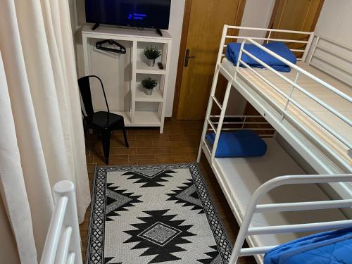a small room with a bunk bed with a television at Alojamiento Rural La Mejora in Conil de la Frontera