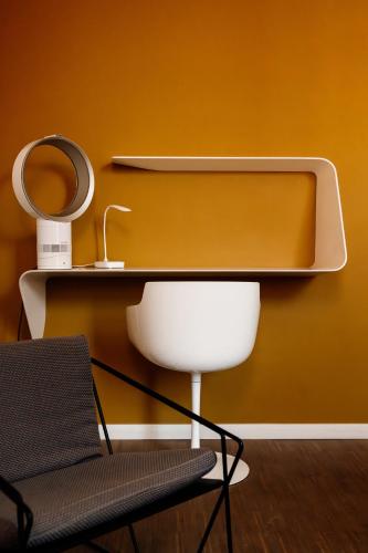 a white chair and a mirror on a wall at Befour in Aalst