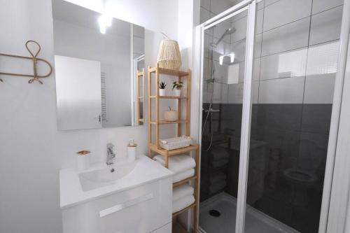 biała łazienka z umywalką i prysznicem w obiekcie Lavilladouce w mieście Moret-sur-Loing