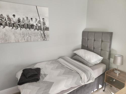 1 dormitorio con 1 cama con una pintura en la pared en Southernwood - Wantage Road Apt 2, en Didcot