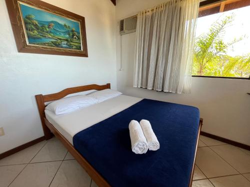 1 dormitorio con 1 cama con 2 toallas en Pousada Mirante, en Florianópolis